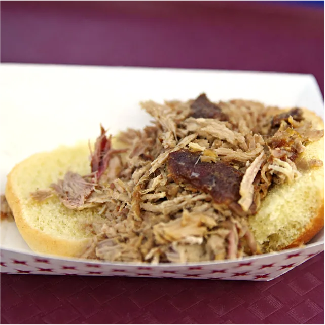 A pulled pork sandwich in a paper boat