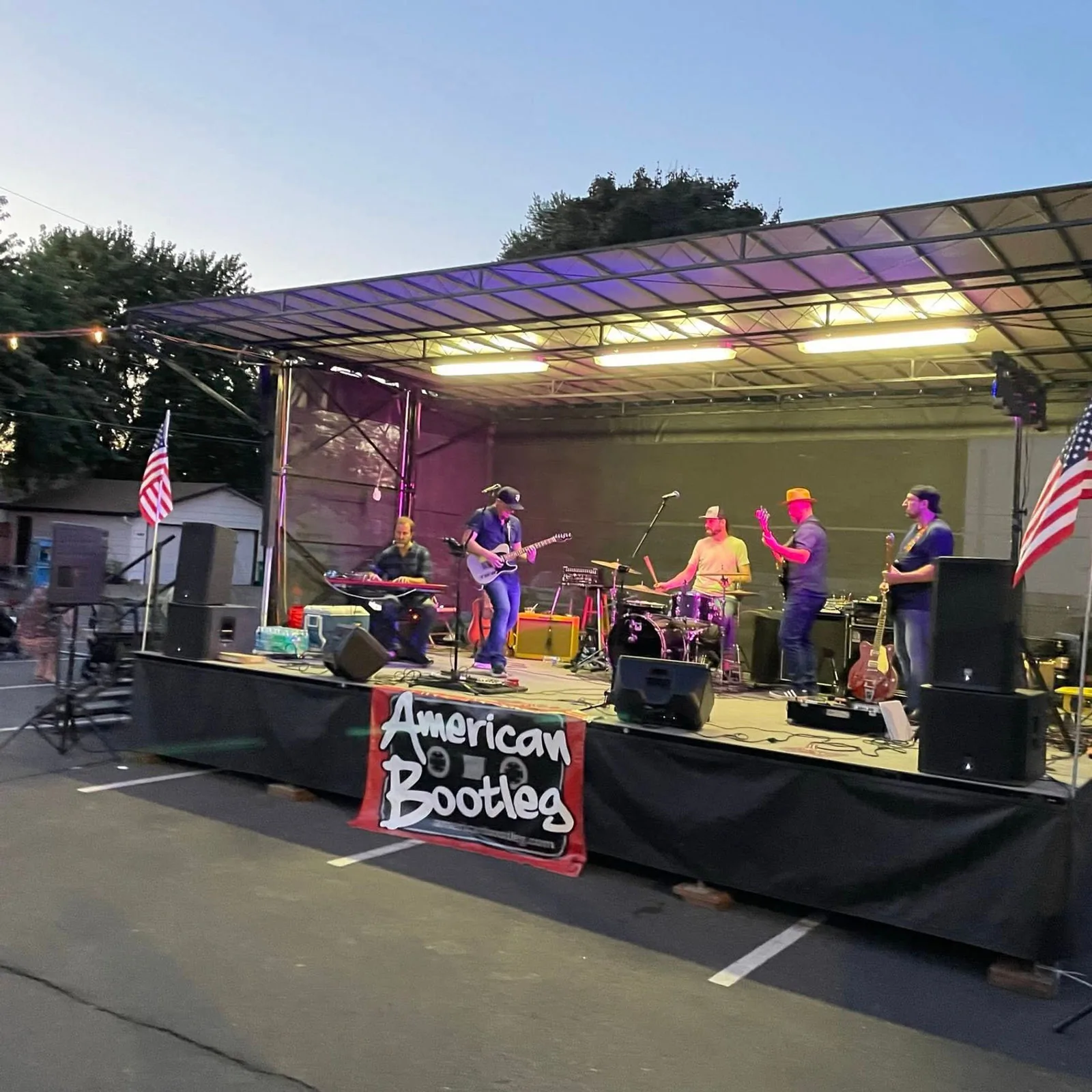 A band performing on the outdoor stage at dusk
